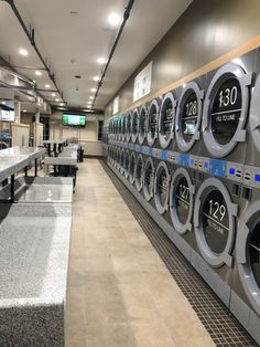 a row of washers in a public laundment with lots of counter space