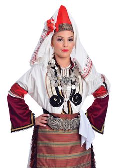 a woman in a traditional costume posing for the camera with her hands on her hips