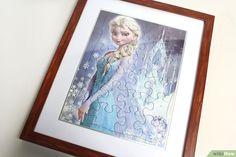 a painting of a frozen princess is hanging on the wall next to a framed piece of puzzle