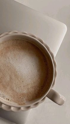 a cup of coffee sitting on top of a white table