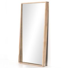 a mirror sitting on top of a white counter next to a wooden framed wall mounted mirror