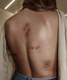 a woman's back with tattoos on it