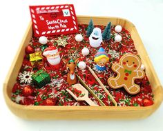 a wooden tray filled with assorted christmas decorations