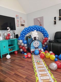 a train themed birthday party with balloons and streamers on the floor in front of it