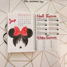 a spiral notebook with mickey mouse's face drawn on it and the date in red