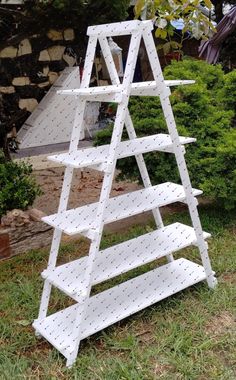 a white wooden shelf sitting in the grass