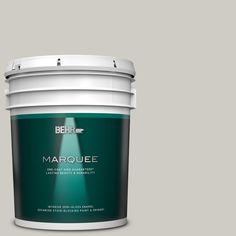 the behr color marquee paint is shown in an open bucket on a gray background