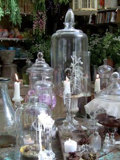 several glass jars and candles on a table