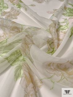 the fabric is white and green with flowers on it