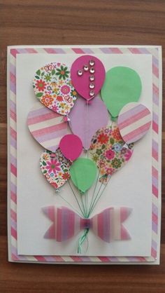 a card with some balloons on it and a bow tie around the bottom of the card