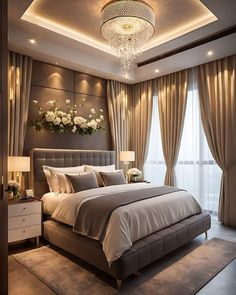 a large bed sitting under a chandelier in a bedroom next to a window