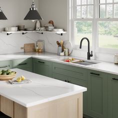 a kitchen with green cabinets and white counter tops, an island in the middle has fruit on it