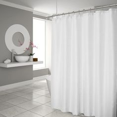 a white shower curtain in a bathroom next to a sink