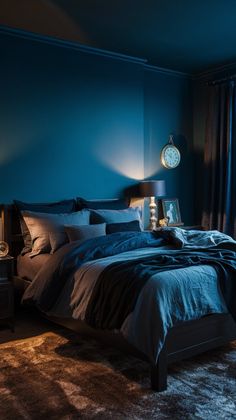 a bed with blue sheets and pillows in a dark room next to a night stand