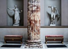 three marble statues are in the middle of a room