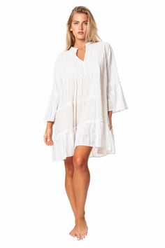 Camella Casual Mini Dress by La Moda. Just as effortless as it is essential, this stunning mini dress is featured in a tiered relaxed body with exaggerated sleeves. The perfect throw-on-and-go mini to pair with a staple sandal in the warmer months or a bold boot in the colder, this cool and classic dress is sure to be your go-to from season to season. 100% Cotton This is a unique garment. The imperfections in these fabrics are not considered defects, but characteristics that make them authentic. Breezy Mini Dress For Beach Cover-up, Flowy Ruffle Sleeve Tiered Vacation Dress, Flowy Tiered Dress With Ruffle Sleeves For Vacation, Ruffle Sleeve Tiered Dress For Vacation, Tiered Ruffle Sleeve Dress For Vacation, Vacation Tiered Dress With Ruffle Details, Vacation Mini Dress With Ruffle Sleeves, Flowy White Tiered Dress For Vacation, Bohemian Mini Dress With Ruffle Hem For Beach