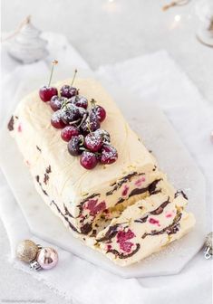 a cake with white frosting and cherries on it