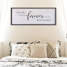 a bed with pillows and a framed sign above it that says, you will forever be my alwayss