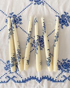 four toothbrushes are lined up on a blue and white tablecloth