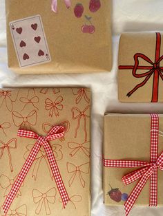 three wrapped presents with bows and hearts on them