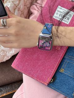 a person holding an apple watch on their wrist and cell phone in her other hand