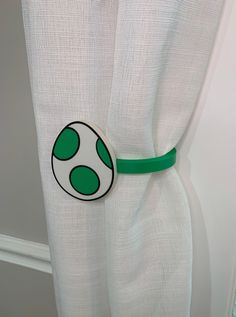 a white curtain with a green belt around it's edge and an image of a mushroom on the side