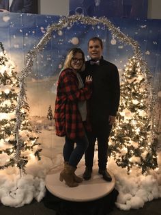 a man and woman standing in front of a christmas display