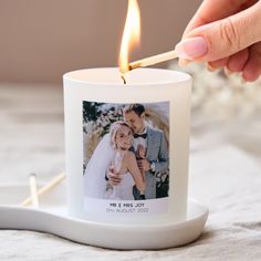 a person lighting a candle with a photo on it and a match in the middle