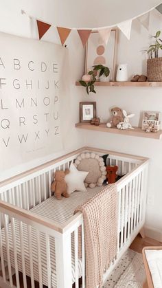 a baby's room with white walls and wooden shelves