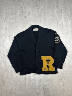 This Vintage 50s Roosevelt High School Cardigan Sweater, in men's size 36, is crafted from luxurious black wool and showcases timeless, classic style. With its retro varsity design, it's a unique piece of history perfect for collectors or those who appreciate vintage school apparel. Please refer to the provided pictures for a detailed view of the condition and measurements of this item. We strive to present our pieces as accurately as possible, ensuring you have a clear understanding of their fi Black Wool Sweater For Streetwear, Classic Black Wool Varsity Jacket, Black Wool Varsity Jacket With Long Sleeves, Classic Black Wool Cardigan, Black Wool Varsity Jacket For College, Classic Winter Cardigan For Streetwear, Vintage Black Sweater For Fall, Classic Wool Varsity Jacket, Retro Streetwear Cardigan For Fall