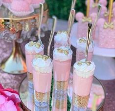 pink and gold desserts are arranged on a table