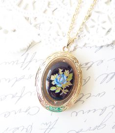 "A gorgeous gold plated photo locket adorned with a lovely vintage black glass limoges with blue rose and gold and green leaves dangles so pretty from a 16k gold plated link chain with lobster clasp. Locket has a lovely floral etched pattern Total length of chain measures 18\" Locket measures 23x30mm Cameo measures 18x13mm Locket is high quality and nickel free Your purchase will come beautifully wrapped ready for gift giving" Heirloom Black Enamel Jewelry For Gift, Heirloom Black Enamel Jewelry As Gift, Vintage Enamel Oval Pendant Jewelry, Vintage Pressed Flowers Jewelry Keepsake, Vintage Pressed Flowers Keepsake Jewelry, Vintage Blue Keepsake Jewelry, Vintage Rose Gold Enamel Jewelry, Vintage Black Enamel Jewelry For Wedding, Vintage Enamel Keepsake Jewelry