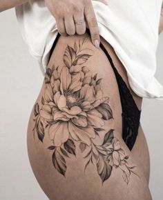 a woman is showing off her thigh with flowers on it