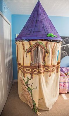 a child's bedroom with a bed and tent in the corner that is decorated like a castle