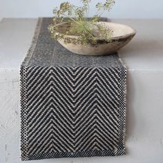 a bowl sitting on top of a table next to a plant