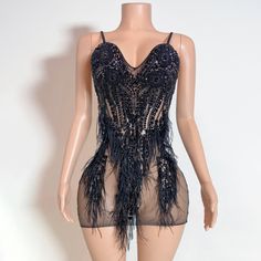 a mannequin wearing a black dress with feathers on it