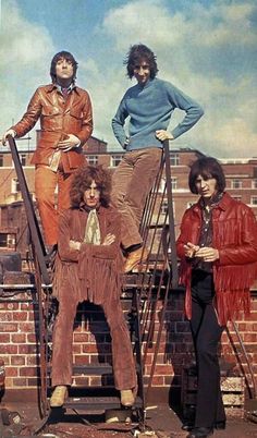 the rolling stones posing for a photo in front of a brick wall and ladders