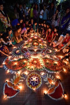 people are gathered around a decorated table with candles and flowers on it, all lit up