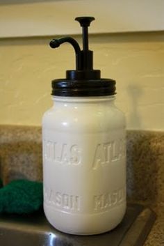 a white mason jar sitting on top of a kitchen sink