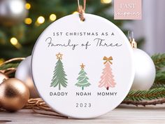 a ceramic ornament with three christmas trees on it and the words first christmas as a family of three