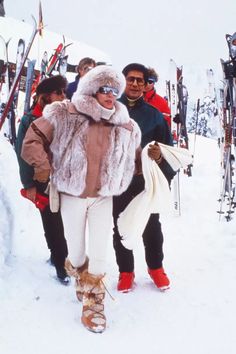 a group of people walking up a snow covered ski slope