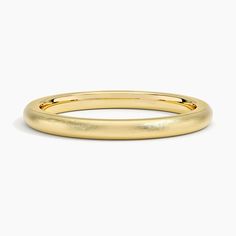 a yellow gold wedding ring on a white background