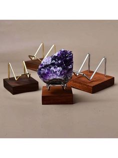 three different types of ametholite displayed on wooden stands with metal rods and wood bases