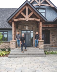 three men standing on the front steps of a house