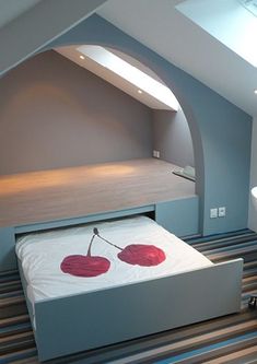 there is a bed with two red hearts on it in the room that looks like an attic