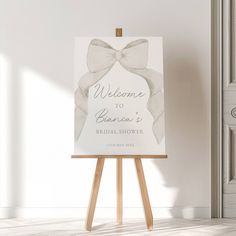 an easel with a welcome sign on it in front of a white wall and door