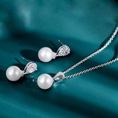 Romantic and elegant, this glowing pearl jewelry set can complete the most sophisticated of bridal looks. A solitaire pearl and cubic zirconia adorn the pendant that is hanging from a delicate chain for a very glamorous look. Necklace: Length - 16.5" (approx. 42cm) plus a 2" (approx. 5cm) extension chain for comfortable sizing. Closure is a secure lobster claw clasp. Earrings: Length: 1" (approx. 2.5cm); Width: 0.4" (approx. 1.1cm). Weight: 4g. Can make a beautiful and thoughtful Bridesmaids or Elegant Pearl White Jewelry Set With Pearl Pendant, Elegant Cubic Zirconia Earrings With Pearl Pendant, Pearl Drop Cubic Zirconia Jewelry Set Gift, Pearl White Round Jewelry Set Gift, Luxury Silver Bridal Necklace With Pearl Charm, Silver Gold Jewelry, Gold Jewelry Sets, Pearl Jewelry Wedding, Pearl Jewelry Sets