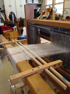 the loom is being worked on by someone who has just finished weaving it in