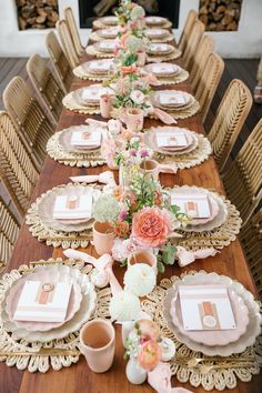 the table is set with pink and white plates, napkins, and vases