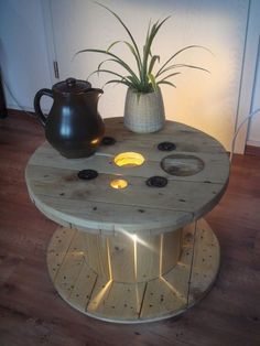 a coffee table made out of pallet wood with lights on it and a potted plant in the center